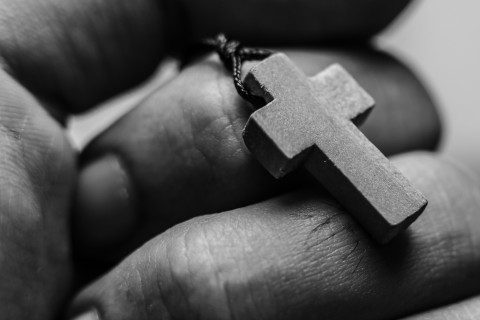 hand holding cross necklace