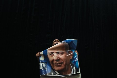 a figure holding a poster of Benjamin Netanyahu