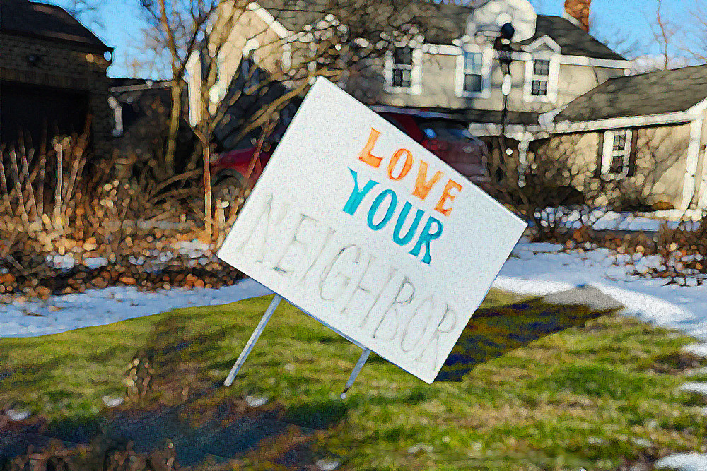 A worn yard sign that says "Love your neighbor"