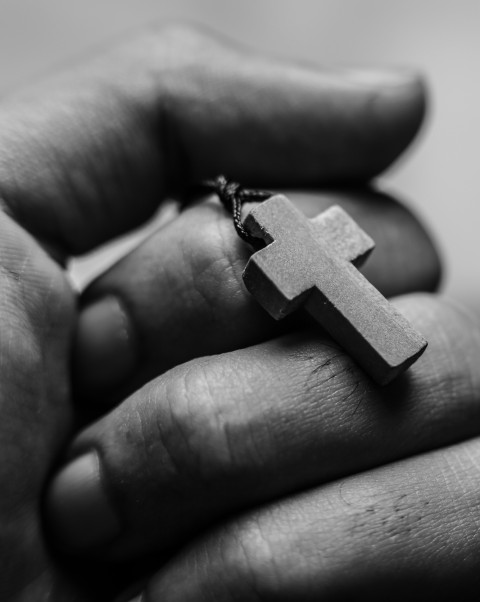 hand holding cross necklace