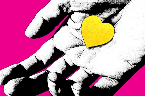 hand holding a yellow heart in the palm of hand